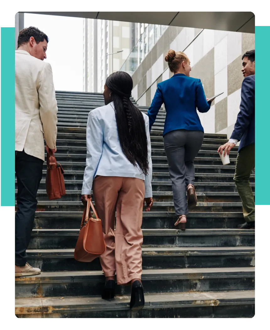 Vier Personen im Gespräch beim Treppensteigen als Symbol für kontinuierliche Verbesserung